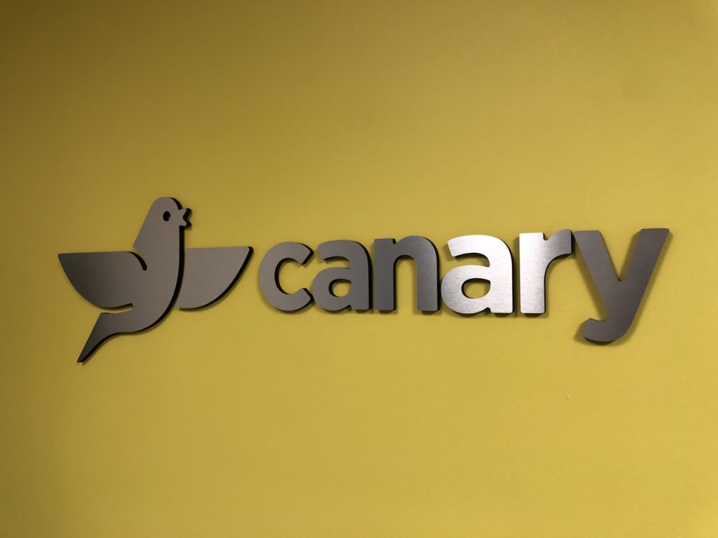 this canary yellow wall looks amazing with brushed aluminum letters